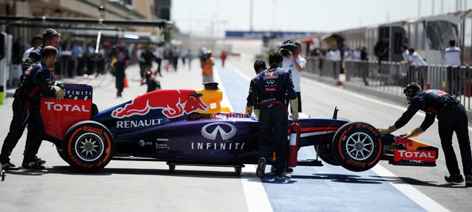 Los mecánicos de Red Bull empujan el RB10 hacia el garaje en Baréin