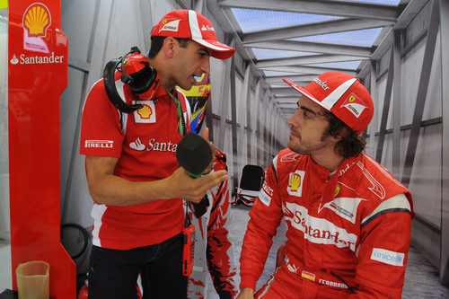 Marc Gené y Fernando Alonso hablan en el box de Ferrari en Valencia