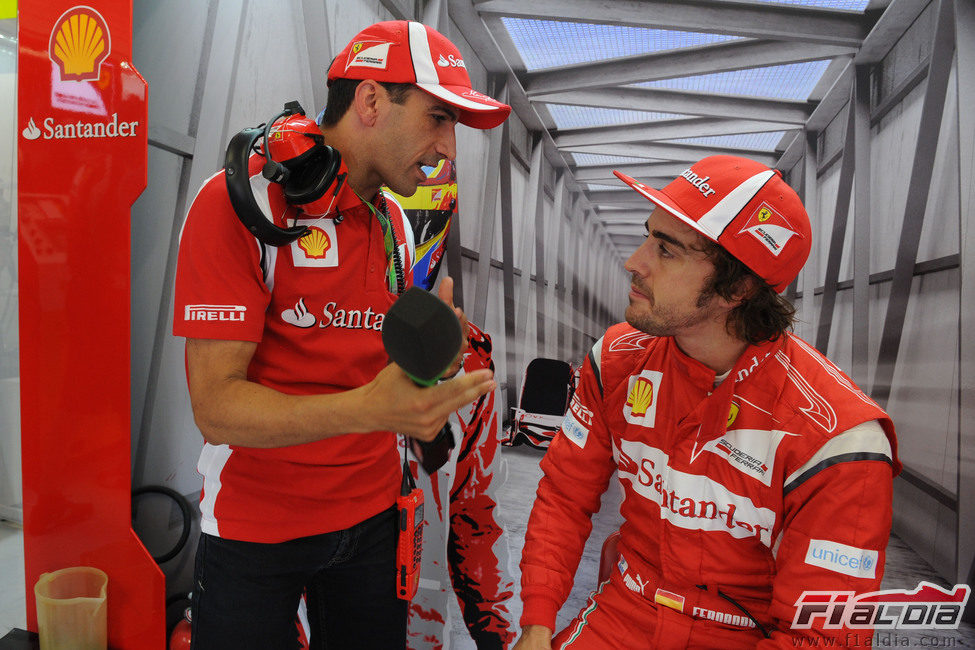 Marc Gené y Fernando Alonso hablan en el box de Ferrari en Valencia