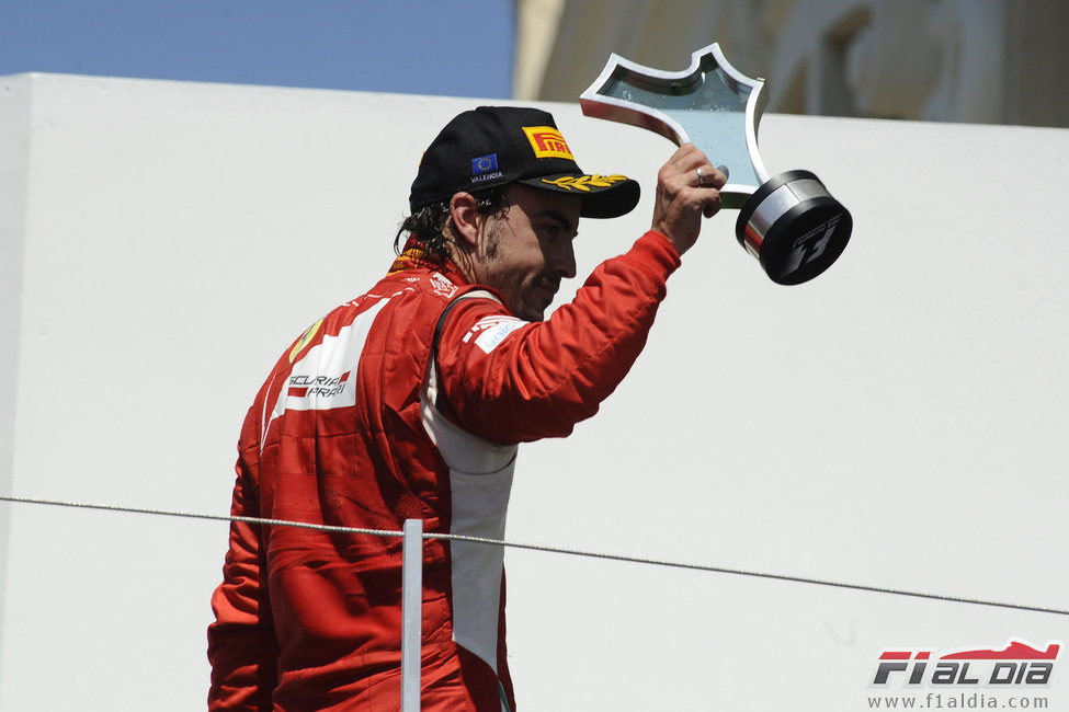 Alonso enseña su trofeo al público español