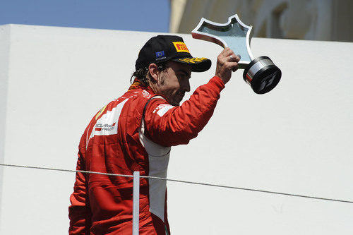 Alonso enseña su trofeo al público español