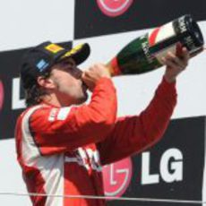 Fernando Alonso bebe de su botella de champán en Valencia