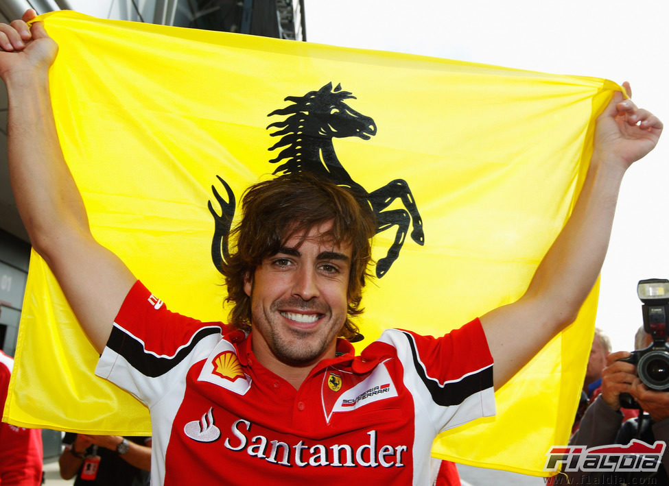 Fernando Alonso celebra su victoria con la bandera de Ferrari