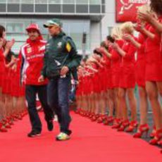 Las 'pitbabes' hacen el pasillo a Alonso y Kovalainen en el GP de Alemania 2011