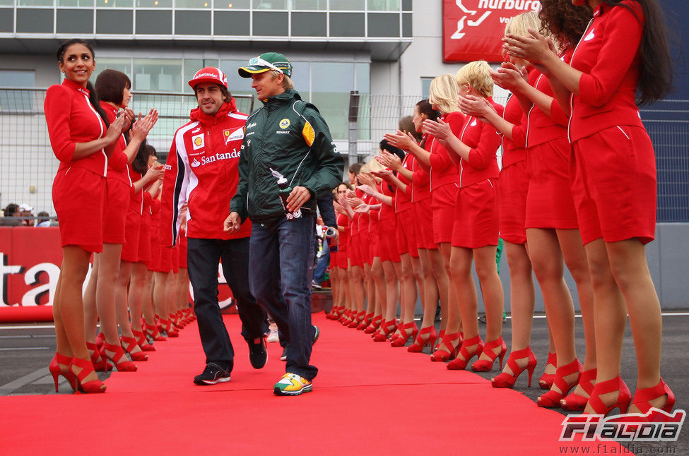 Las 'pitbabes' hacen el pasillo a Alonso y Kovalainen en el GP de Alemania 2011
