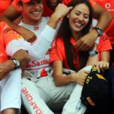 Hamilton abraza a Button y Jessica Michibata en la celebración del equipo en Hungría 2011