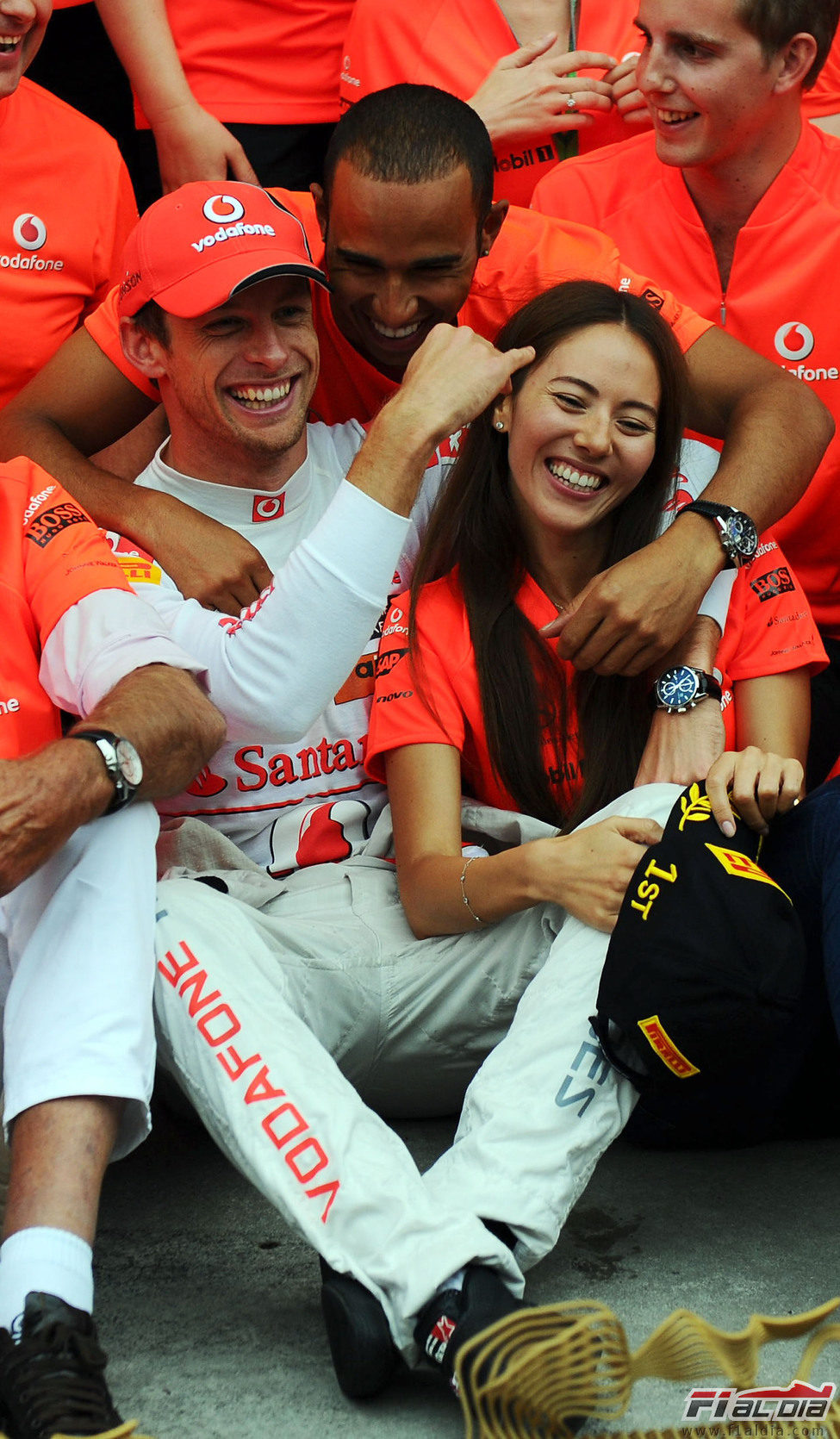 Hamilton abraza a Button y Jessica Michibata en la celebración del equipo en Hungría 2011