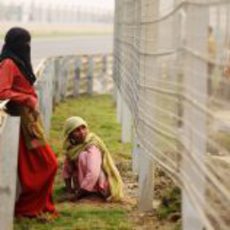 Mujeres indias terminan de plantar el césped del circuito