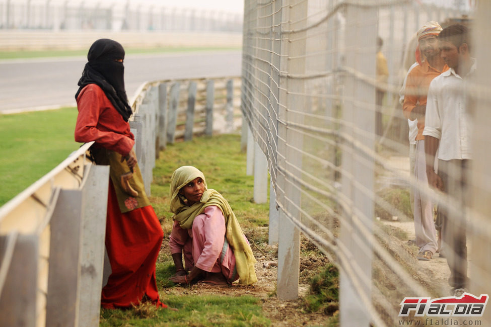 Mujeres indias terminan de plantar el césped del circuito