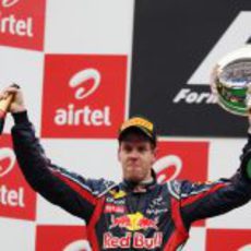 Vettel levanta en India su botella de champán y su trofeo