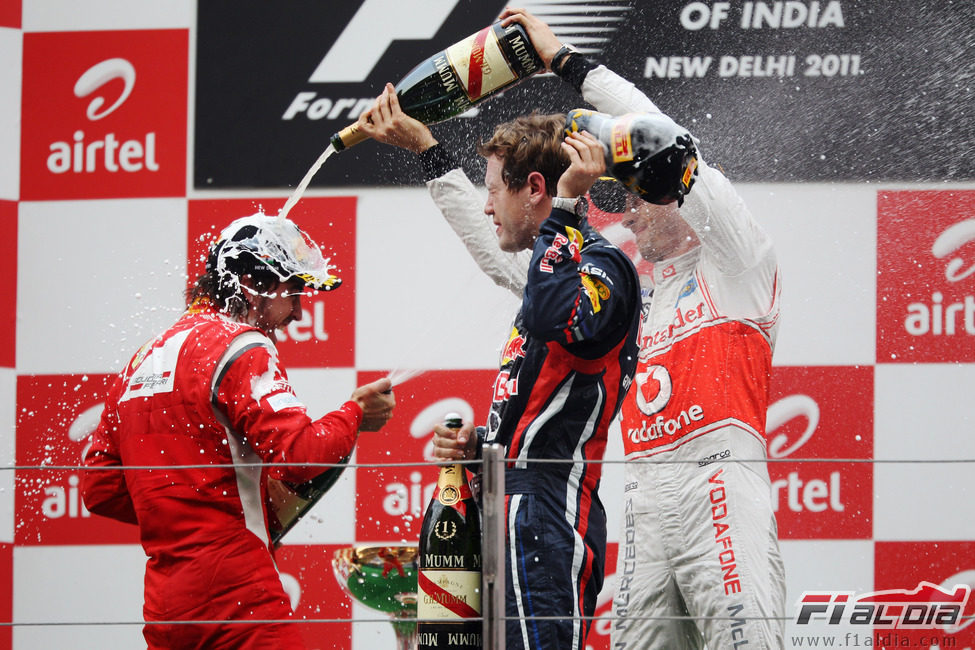 Button empapa a Alonso en champán en el GP de India 2011