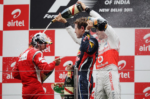 Button empapa a Alonso en champán en el GP de India 2011