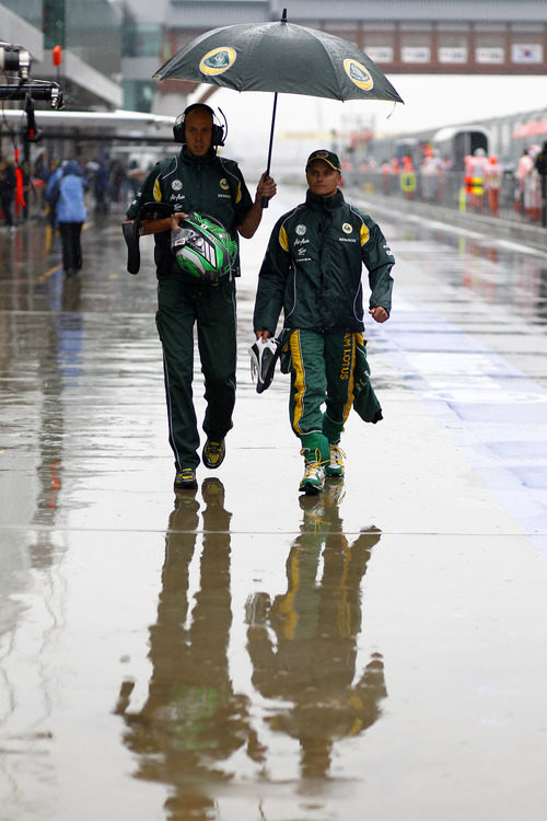 Heikki Kovalainen bajo un paraguas en el 'paddock' de Yeongam