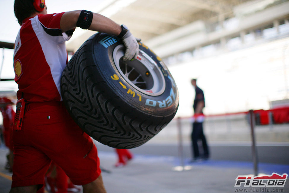 Un mecánico de Ferrari lleva un neumático intermedio en Corea