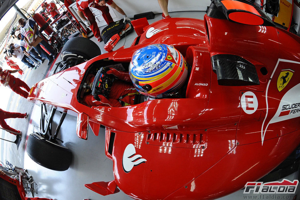 Alonso sentado en su Ferrari en el box de Interlagos 2011