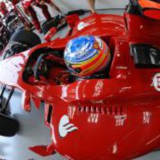 Alonso sentado en su Ferrari en el box de Interlagos 2011