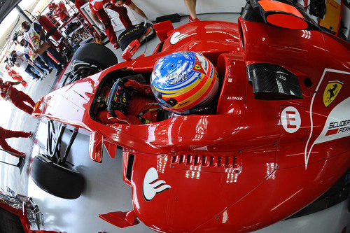 Alonso sentado en su Ferrari en el box de Interlagos 2011