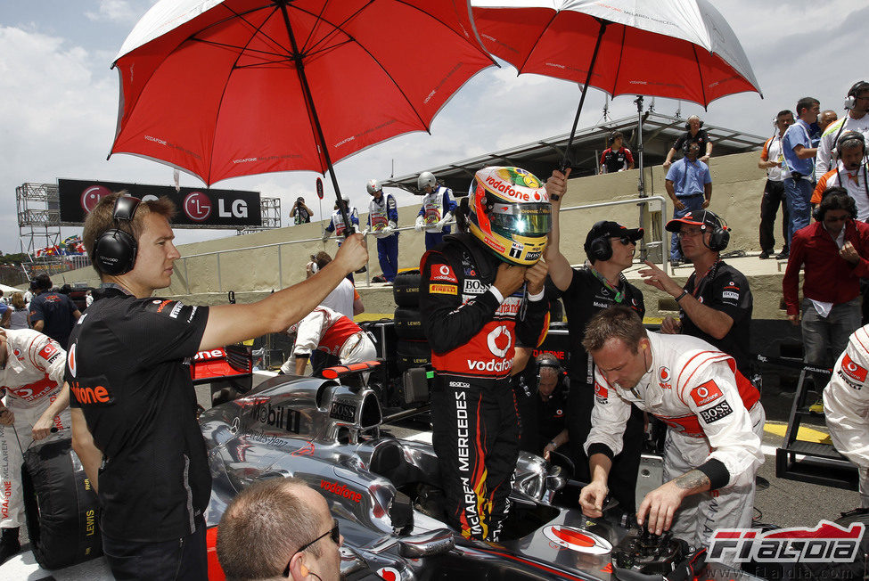 Lewis Hamilton se sienta en su monoplaza en la parrilla del GP de Brasil 2011