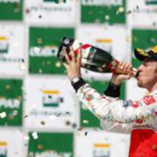 Jenson Button bebe champán en le podio de Brasil 2011