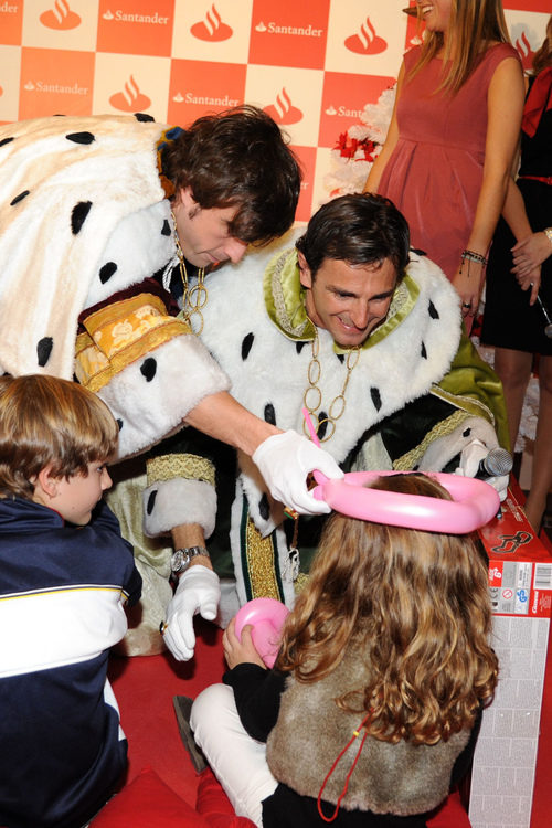 Fernando Alonso y Pedro de la Rosa bromean con una niña