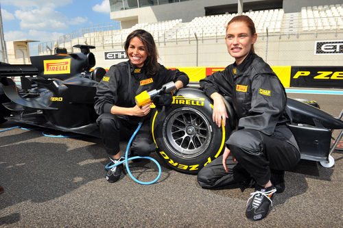 Inés Sastre y Bianca Balti intentan cambiar un neumático de Fórmula 1