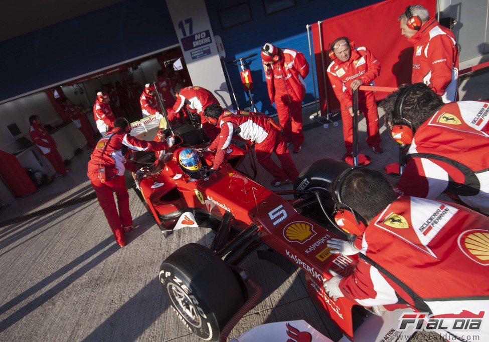 Los mecánicos meten el Ferrari de Alonso en boxes