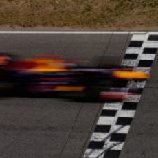 Sebastian Vettel pasa a toda velocidad por la línea de meta