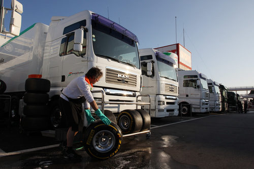 Un mecánico baja los Pirelli del camión de Force India
