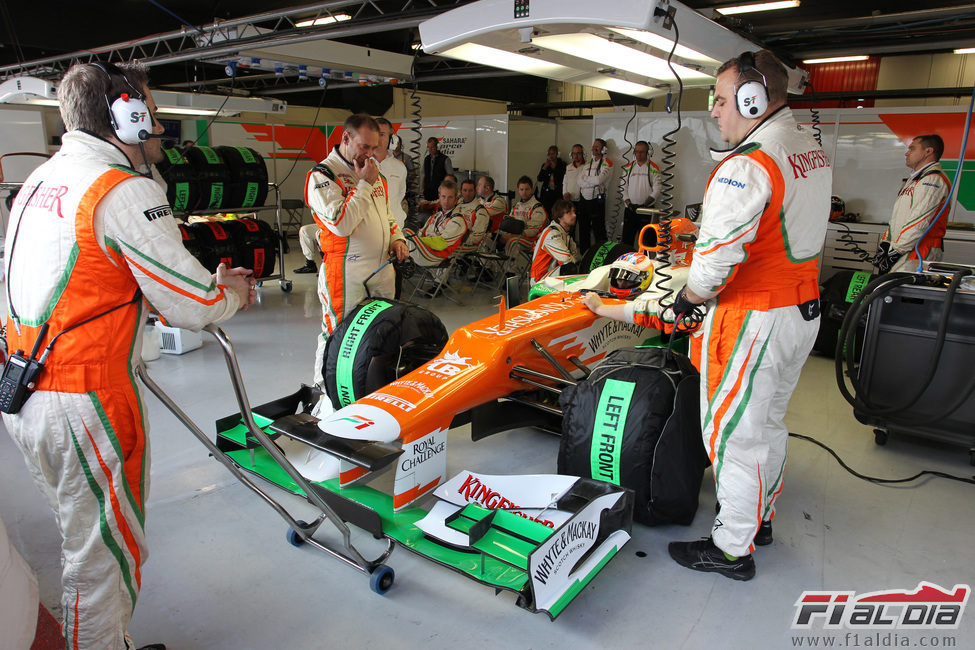 Di Resta sentado en el coche mientras los mecánicos hablan