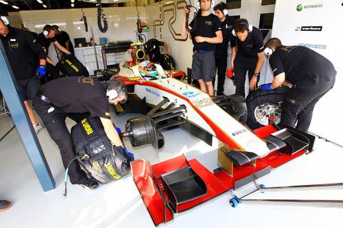 Narain Karthikeyan en el garaje rodeado por los mecánicos