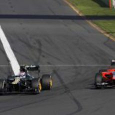 Vitaly Petrov adelanta a Timo Glock en la primera curva de Albert Park