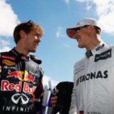 Sebastian Vettel charla con Michael Schumacher antes de la carrera