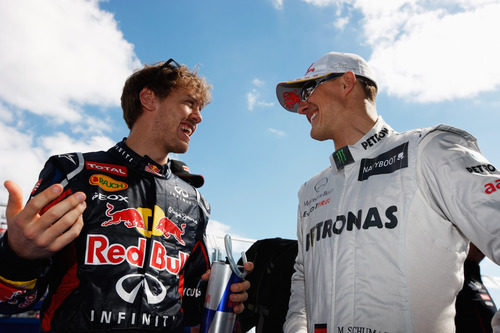 Sebastian Vettel charla con Michael Schumacher antes de la carrera