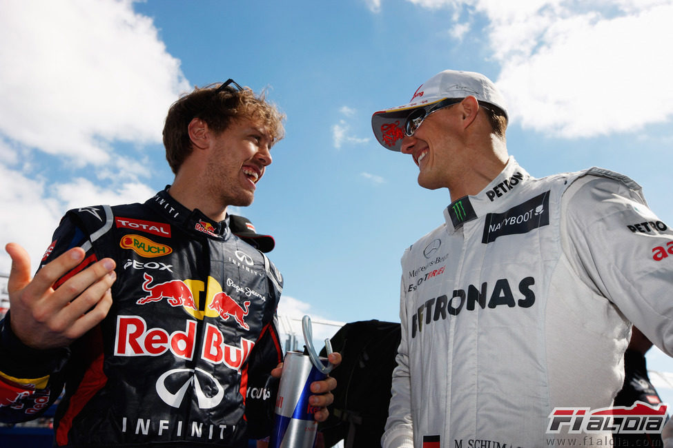 Sebastian Vettel charla con Michael Schumacher antes de la carrera