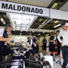 Pastor Maldonado mira como ponen a punto su FW34 durante los primeros libres del GP de Australia 2012