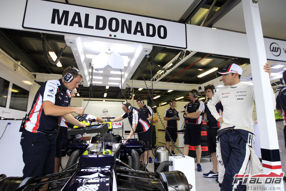 Pastor Maldonado mira como ponen a punto su FW34 durante los primeros libres del GP de Australia 2012