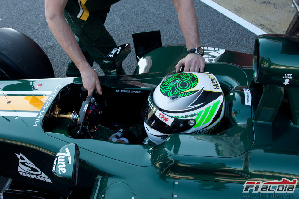 Un mecánico ayuda a Kovalainen a meter su monoplaza en boxes