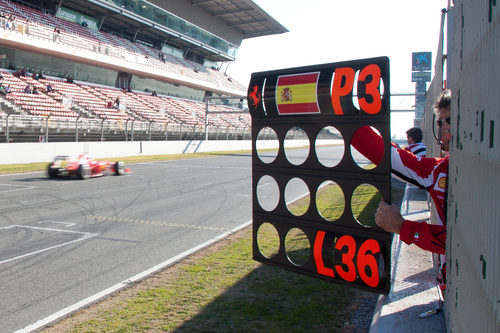 Un mecánico de Ferrari muestra la pizarra a Alonso