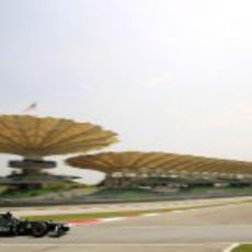 Vitaly Petrov con la grada principal del Circuito de Sepang al fondo