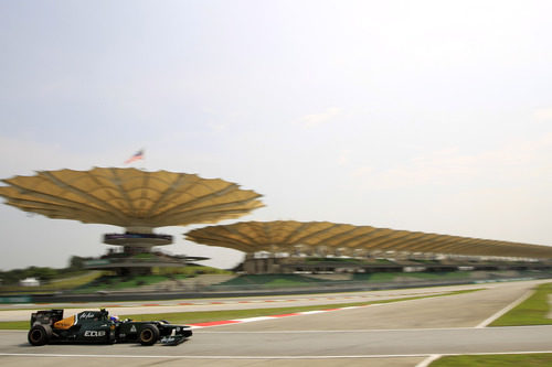 Vitaly Petrov con la grada principal del Circuito de Sepang al fondo