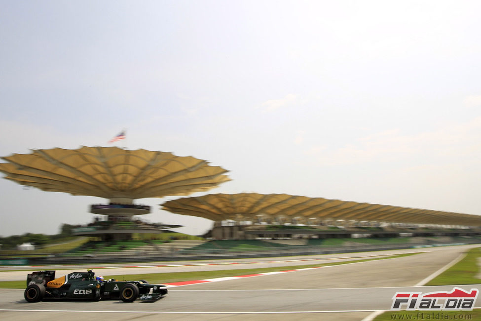 Vitaly Petrov con la grada principal del Circuito de Sepang al fondo