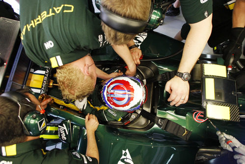 Vitaly Petrov ayudado por los mecánicos para acomodarse en el Caterham