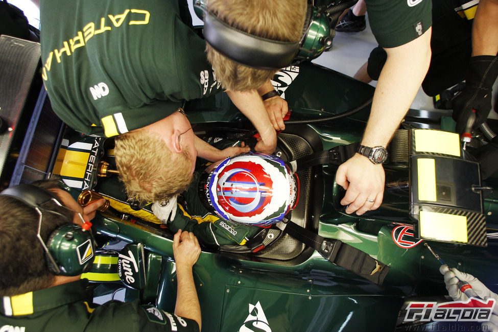 Vitaly Petrov ayudado por los mecánicos para acomodarse en el Caterham