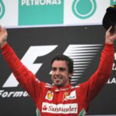 Fernando Alonso levanta los brazos en el podio del GP de Malasia 2012