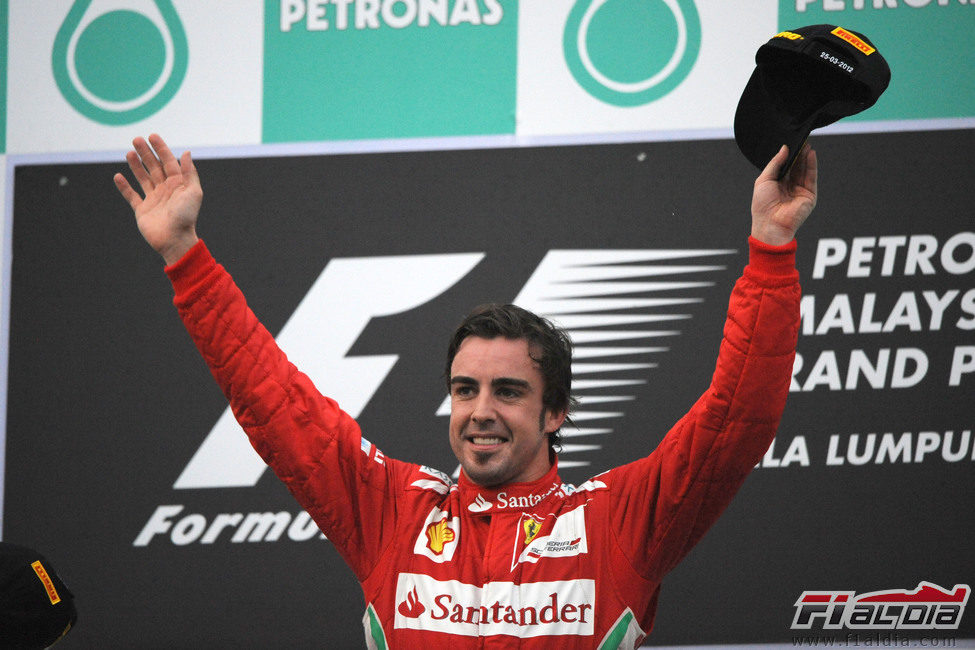 Fernando Alonso levanta los brazos en el podio del GP de Malasia 2012