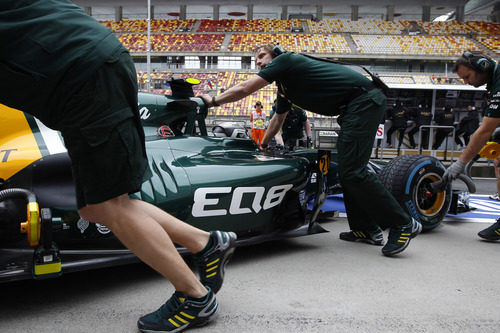 Los mecánicos meten en el box el coche de Giedo van der Garde