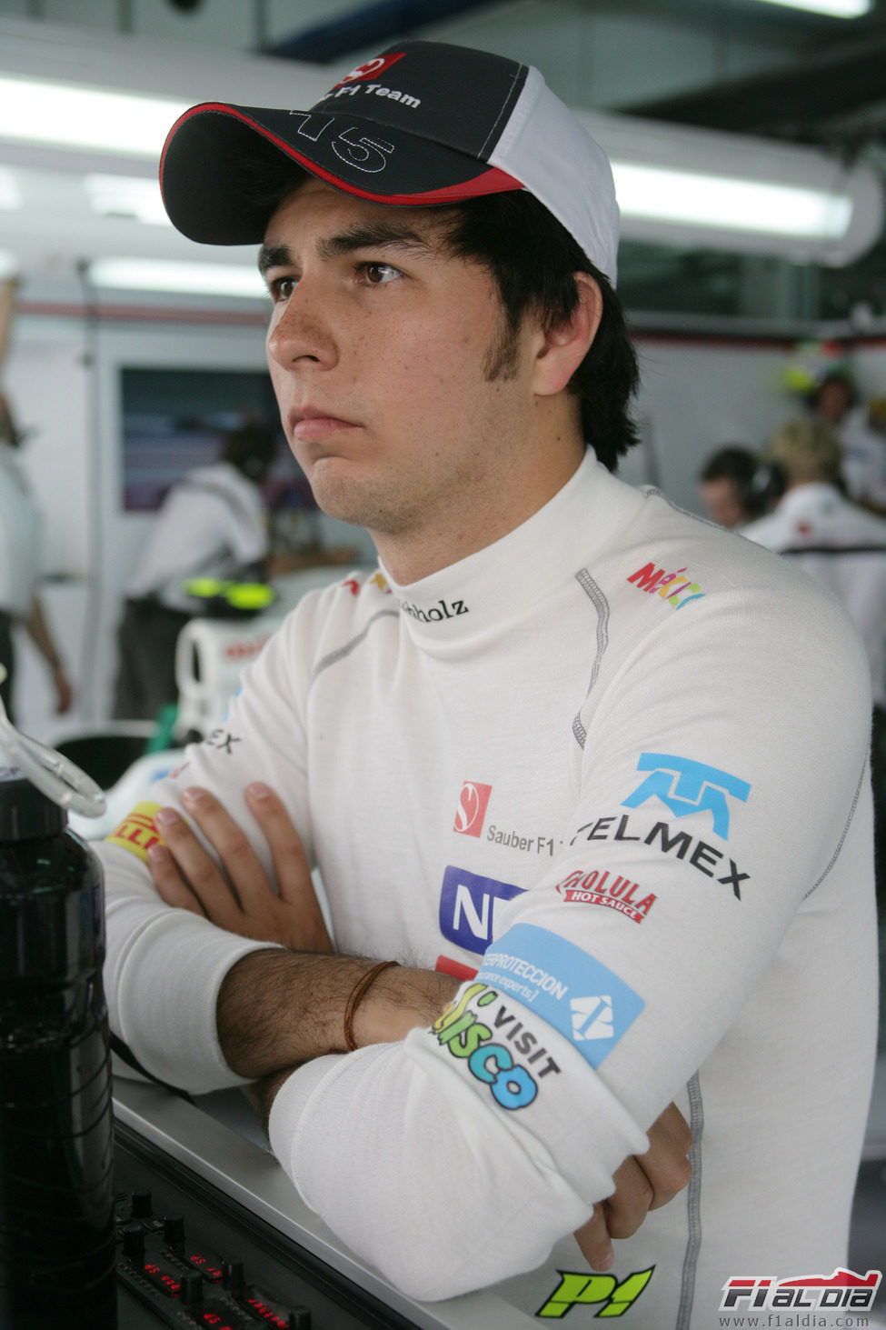 Sergio Pérez con gesto serio en el box de Sauber