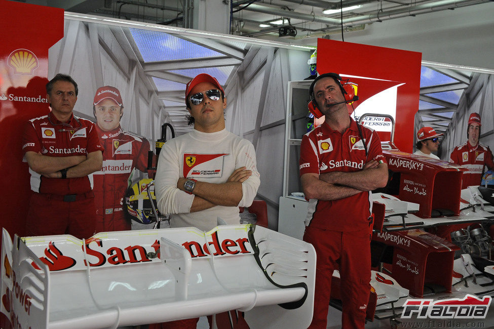 Felipe Massa mira la televisión en el box de Ferrari