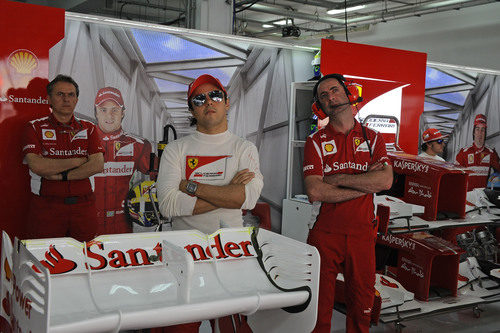 Felipe Massa mira la televisión en el box de Ferrari