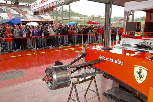 Los seguidores hacen fotos al 'box' del equipo Ferrari